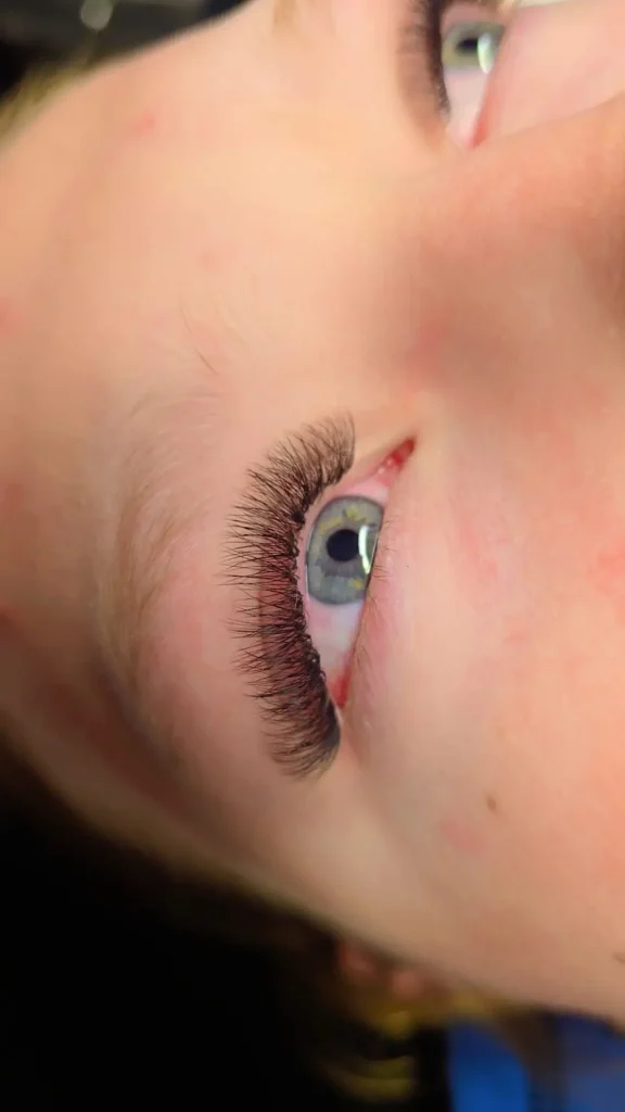 Wispy volume eyelash extensions framing green eyes